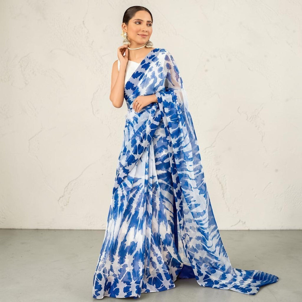 Zarfina digital printed blue and white chiffon saree with a raw silk blouse worn by a model.