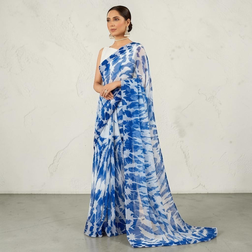 Zarfina digital printed blue and white chiffon saree with a sleeveless raw silk blouse for formal occasions.