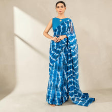 Zarfina digital printed blue and white chiffon saree with a matching raw silk sleeveless blouse for formal occasions.